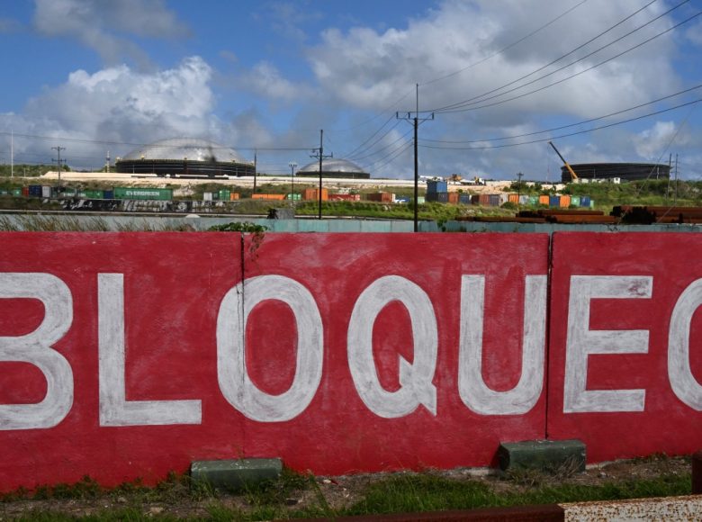 This view shows a mural reading blockade, with several fuel storage tanks in the background in the industrial zone of Matanzas, Cuba, on March 31, 2026. (Photo by YAMIL LAGE / AFP)