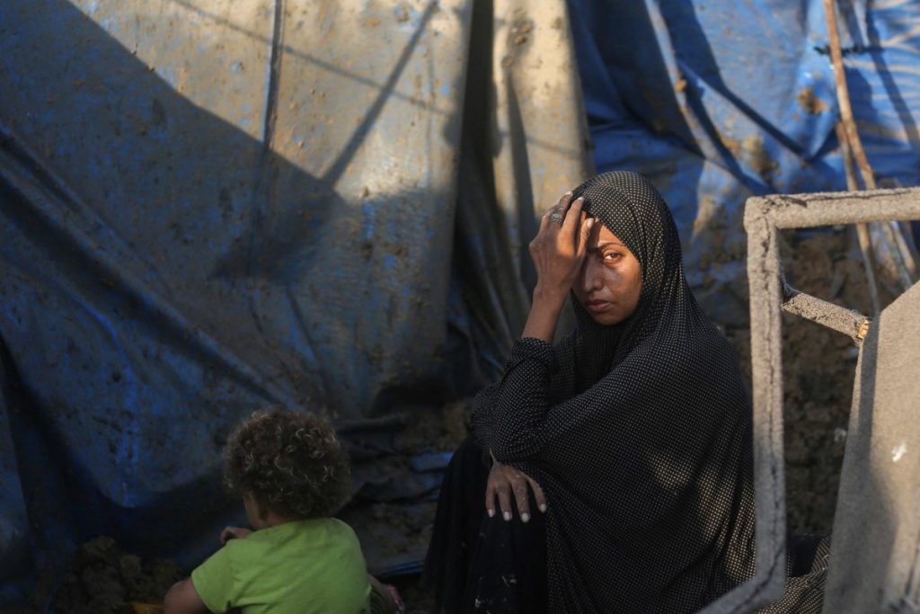 A displaced Palestinians sits outside tents following an Israeli airstrike that targeted the medical supplies and pharmaceuticals warehouse of Al-Aqsa Martyrs Hospital, in Deir al-Balah, central Gaza Strip on August 1, 2026. Hamas said on July 31, 2026, it had agreed to a deal that includes handing over its weapons to a Palestinian governing committee and the gradual withdrawal of Israeli forces from the Gaza Strip. Israel has yet to officially comment on the announcement, but a political source told AFP "that there will be no withdrawal whatsoever" from Israeli forces' current lines "unless Hamas undergoes a genuine disarmament". (Photo by Eyad Baba / AFP)