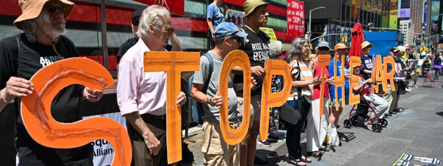 Demonstrators hold signs and display photos of American soldiers and civilians who died in the conflict during a ''Stop the War'' demonstration in Times Square, New York City, on August 9, 2026. The event was organized in collaboration with the group ''Rise & Resist NYC.'' (Photo by Waleed Ibrahim/NurPhoto) (Photo by Waleed Ibrahim / NurPhoto via AFP)