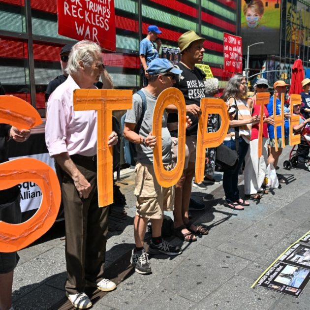 Demonstrators hold signs and display photos of American soldiers and civilians who died in the conflict during a ''Stop the War'' demonstration in Times Square, New York City, on August 9, 2026. The event was organized in collaboration with the group ''Rise & Resist NYC.'' (Photo by Waleed Ibrahim/NurPhoto) (Photo by Waleed Ibrahim / NurPhoto via AFP)