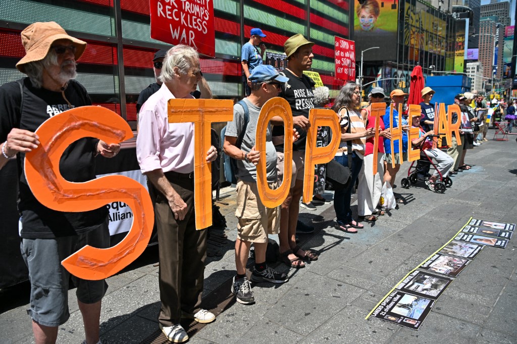 Demonstrators hold signs and display photos of American soldiers and civilians who died in the conflict during a ''Stop the War'' demonstration in Times Square, New York City, on August 9, 2026. The event was organized in collaboration with the group ''Rise & Resist NYC.'' (Photo by Waleed Ibrahim/NurPhoto) (Photo by Waleed Ibrahim / NurPhoto via AFP)
